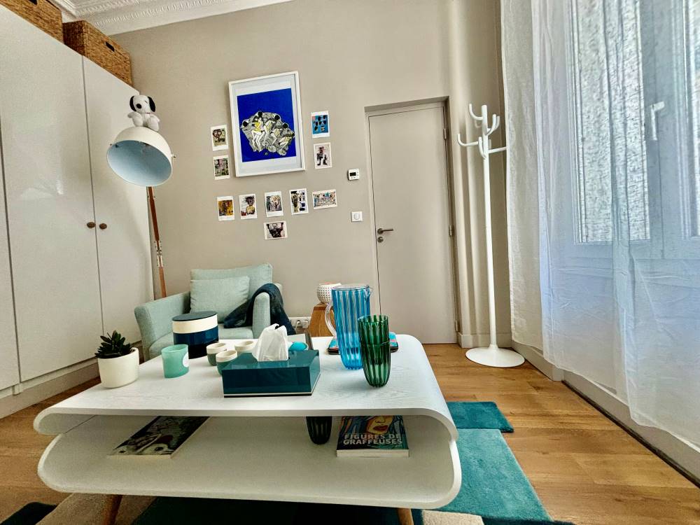 Le cabinet de thérapie — fauteuil bleu, table basse blanche, ambiance lumineuse