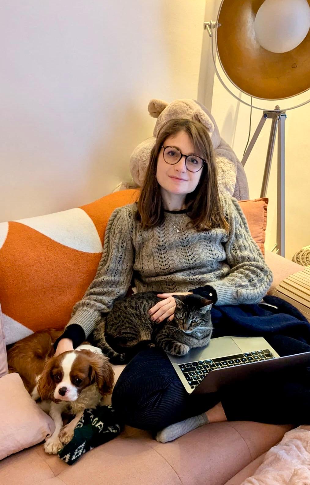 Rébecca chez elle, Atarax la chienne et l'une des chattes sur le canapé, MacBook sur les genoux